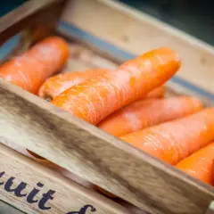 Pomarańczowa marchewka w drewnianej skrzynce, gotowa na zdrowy posiłek.