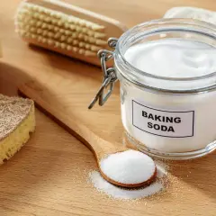 Słoik z sodą oczyszczoną i łyżka z proszkiem. Soda oczyszczona ma właściwości bakteriobójcze, idealna do sprzątania.