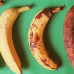Cztery banany na zielonym tle: od jasnożółtego, przez lekko nakrapiany, po prawie czarny. Idealny banan na noc.