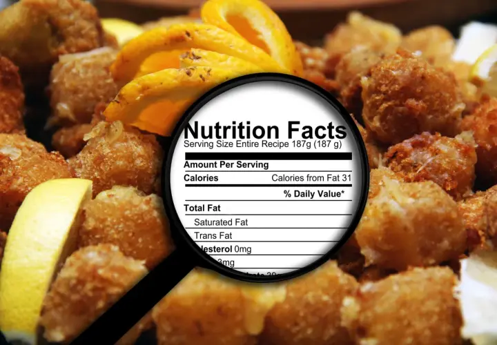 Smażone przekąski z cytryną, pod lupą etykieta "Nutrition Facts", gdzie widać "Trans Fat". Dowiedz się, tłuszcze trans co to jest i jak wpływają na zdrowie.