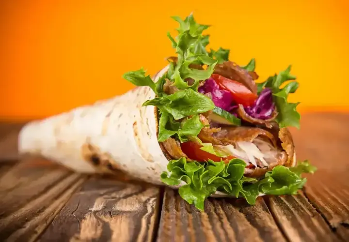 Pyszny kebab w tortilli, pełen mięsa, warzyw i sosu. Idealny na szybki posiłek, choć warto pamiętać o jego tortilla kcal.