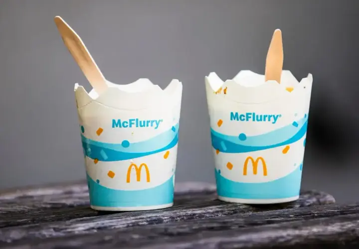 Dwa kubeczki McFlurry z drewnianymi łyżeczkami. Idealne na deser, ale warto sprawdzić mcflurry kcal przed spożyciem.