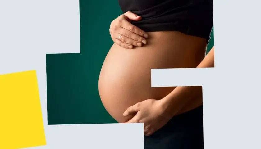 Brzuch kobiety w ciąży, wspierany dłońmi. Dbałość o skórę i elastyczność, wsparcie dla kolagenu w ciąży.