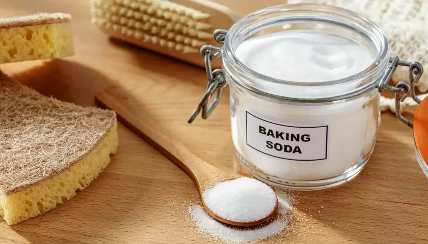 Słoik z sodą oczyszczoną i łyżka z proszkiem. Soda oczyszczona ma właściwości bakteriobójcze, idealna do sprzątania.