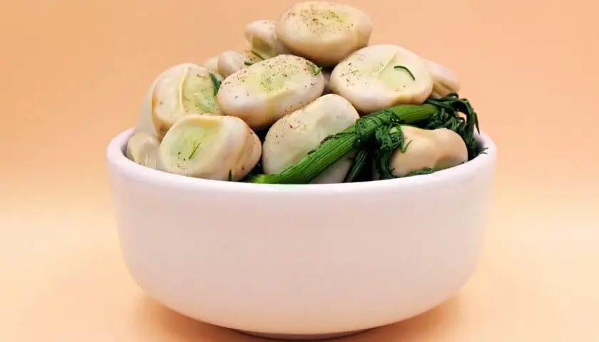 Miseczka pełna bobu z zielonymi ziołami. Zastanawiasz się, ile kcal ma bob? To pyszna i zdrowa przekąska!