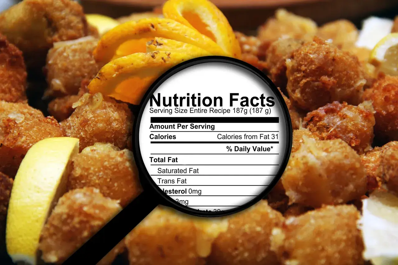 Smażone przekąski z cytryną, pod lupą etykieta "Nutrition Facts", gdzie widać "Trans Fat". Dowiedz się, tłuszcze trans co to jest i jak wpływają na zdrowie.