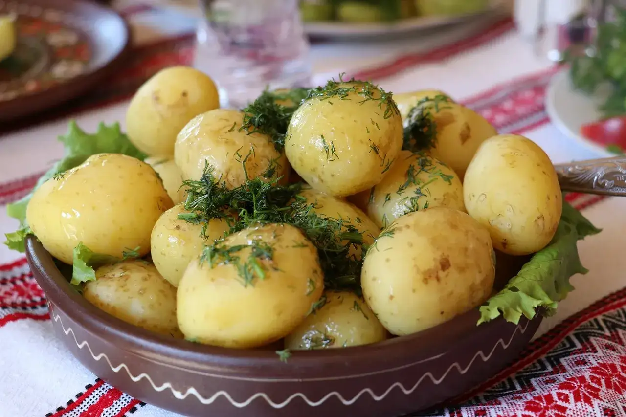 Młode ziemniaki z koperkiem, podane na liściach sałaty. Czy ziemniaki są zdrowe? Tak, zwłaszcza te młode, gotowane w mundurkach!